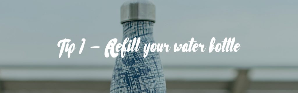 Image source is Photo by bady qb on Unsplash. In the background is the top of a stainless steel water bottle with a silver top and a blue/white pattern. In the foreground in white text it reads 'Tip 7 - Refill your water bottle'