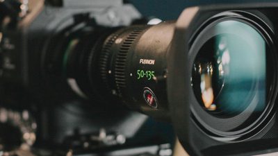 Photo of a Fujinon Zoom leans on a camera