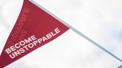 Become Unstoppable written on a red flag blowing in the wind