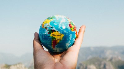 Photo of a person's hand holding a small globe