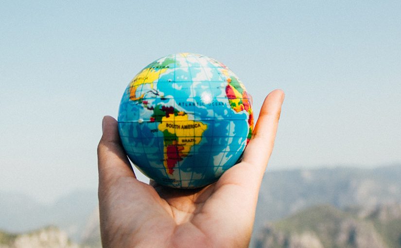 Photo of a person's hand holding a small globe