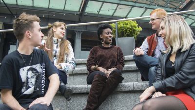 Photo of different students sitting and talking to each other
