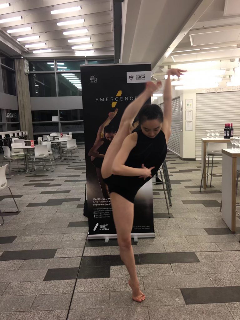 Wenwen posing in front of the Emergence sign