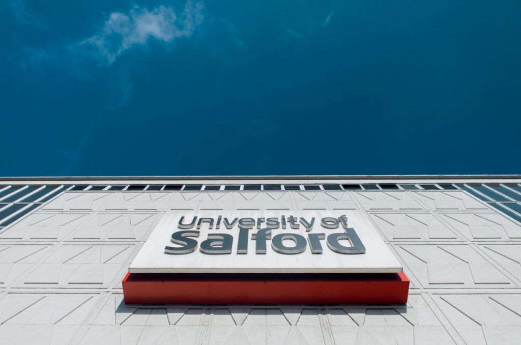 Sign on a campus building that reads "University of Salford"
