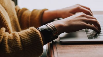 Photo of person's hand typing in her laptop