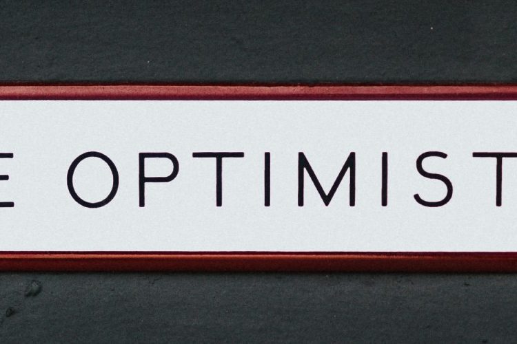 Photo of text "Be Optimistic" written in Black Capital Letters in a White Background