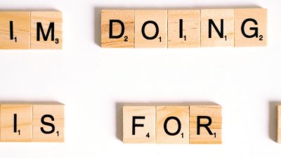 Photo of alphabet blocks arranged to make a sentence saying "IM DOING THIS FOR ME"