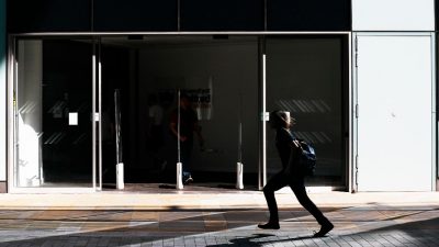 Image of the entrance to the University of Salford MCUK building, with a person walking across.