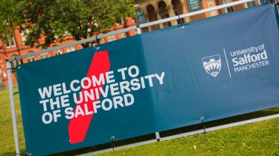 A sign outside of Campus saying "Welcome to the University of Salford."