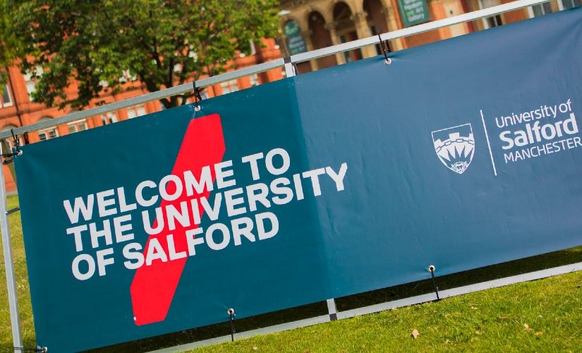A sign outside of Campus saying "Welcome to the University of Salford."