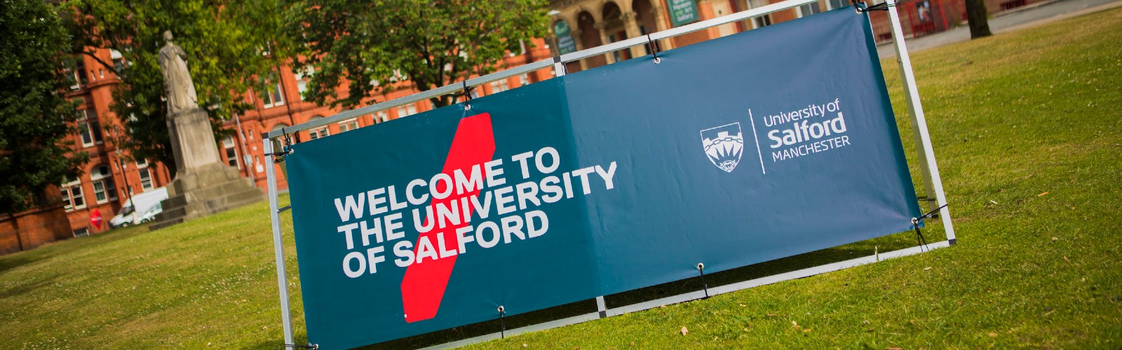 A sign outside of Campus saying "Welcome to the University of Salford."