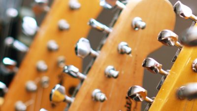 Image of the headstock and tuning pegs of several guitars