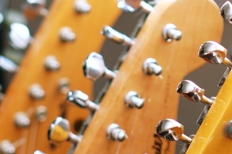 Image of the headstock and tuning pegs of several guitars