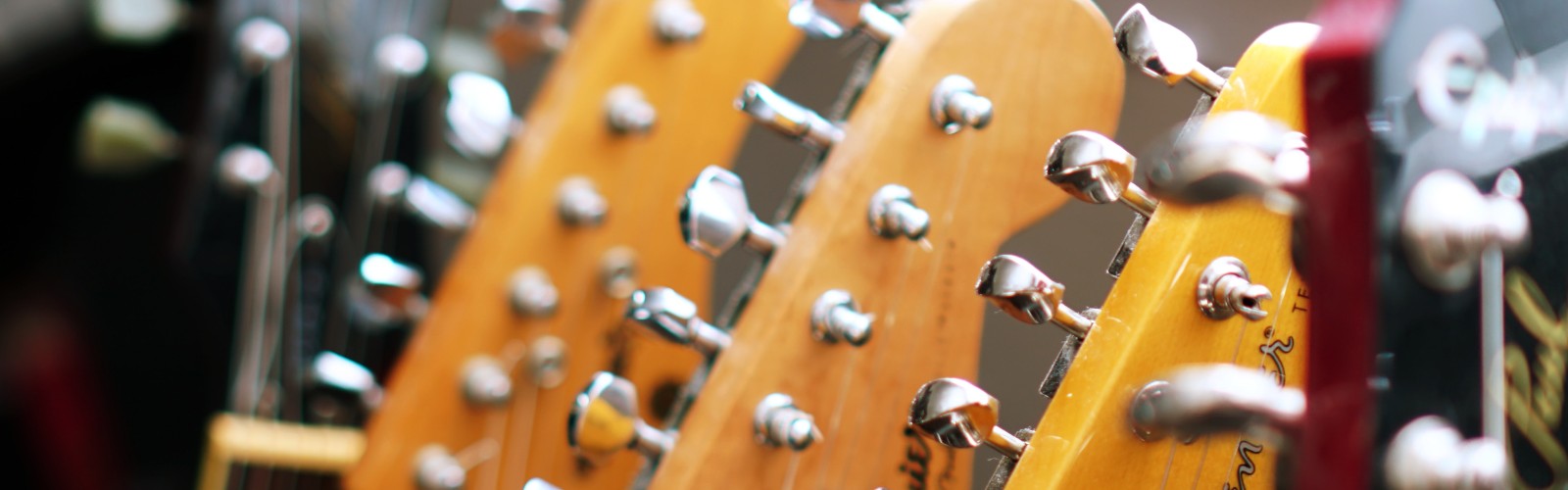 Image of the headstock and tuning pegs of several guitars