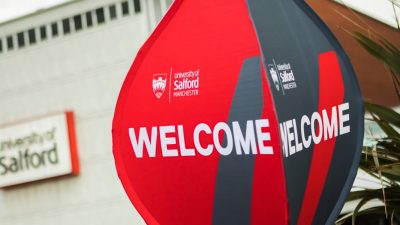 Photo of Uni of Salford welcome Balloon sign with university of Salford sign in the background blurred