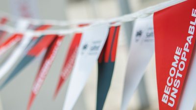 'Become Unstoppable' written on red, white and grey flags