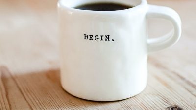 Image of a coffee mug with the word "begin" printed on it