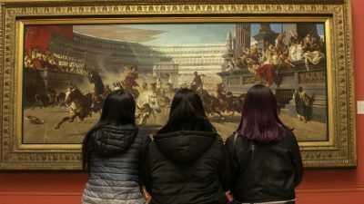 Photo of friends from the back looking at the painting inside the art gallery