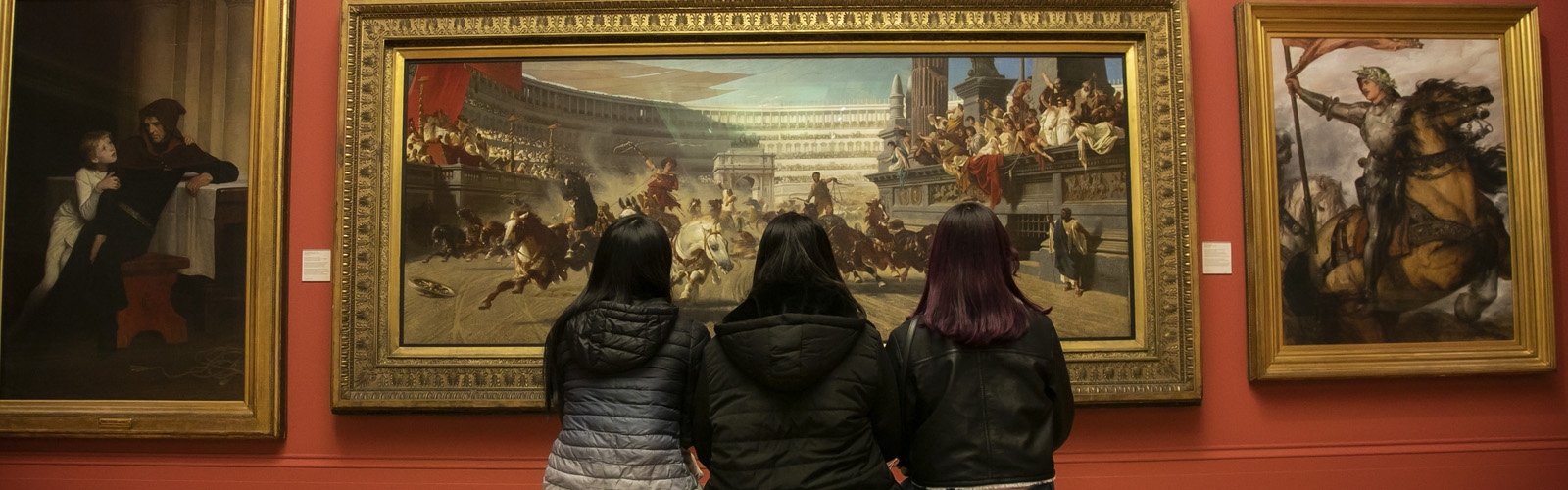 Photo of friends from the back looking at the painting inside the art gallery