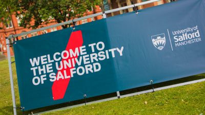 Photo of Uni of Salford Welcome Banner infront of Maxwell Building