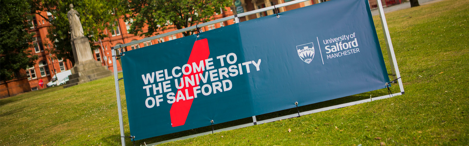 Photo of Uni of Salford Welcome Banner infront of Maxwell Building