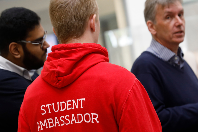 Photo from the back with the volunteer wearing the salford uni student red student ambassdor hoodie