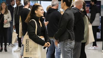 Photo of women wearing a black jacekt with a tote bag talking to counsellor wearing gray blazer