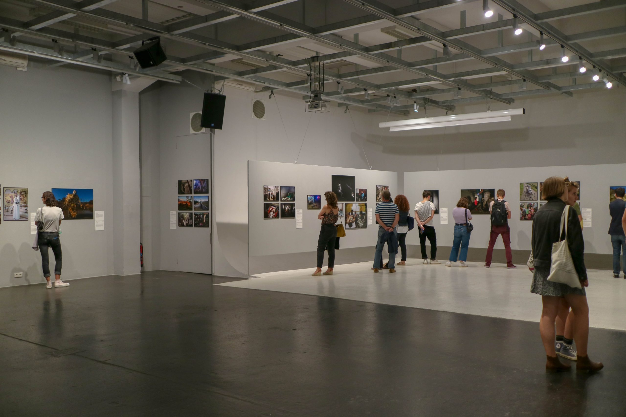 A group of people in an art gallery looking at photographs