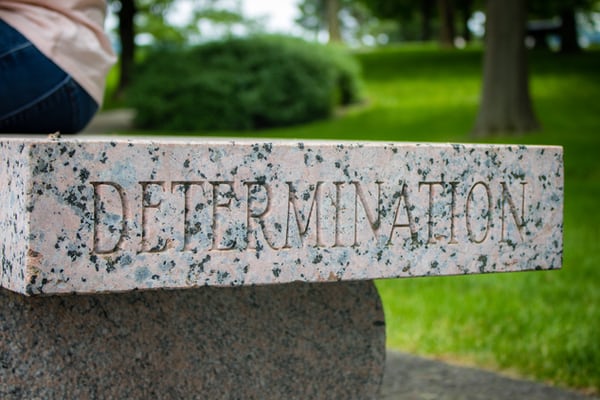 Determination written on a stone bench