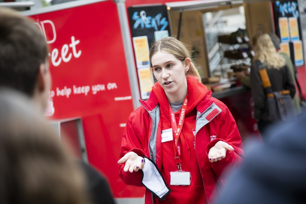 Student volunteer talking to guests at an Open Day