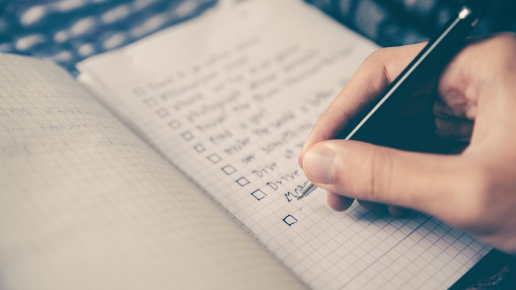 photo of someone writing a checklist in a notebook