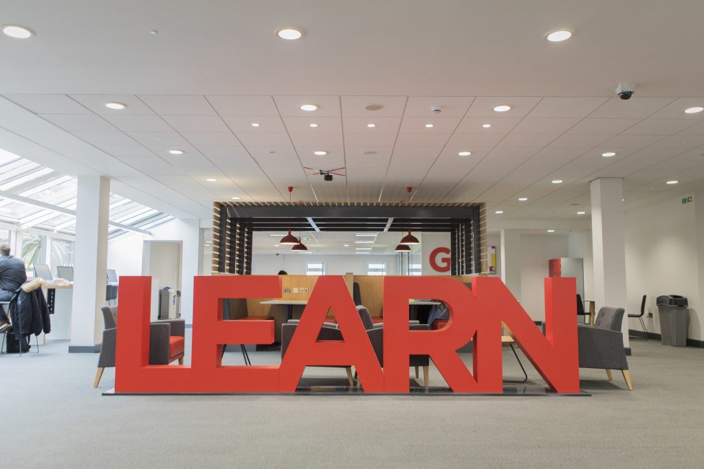 Photo of a large "Learn" sign in The University of Salford's Library