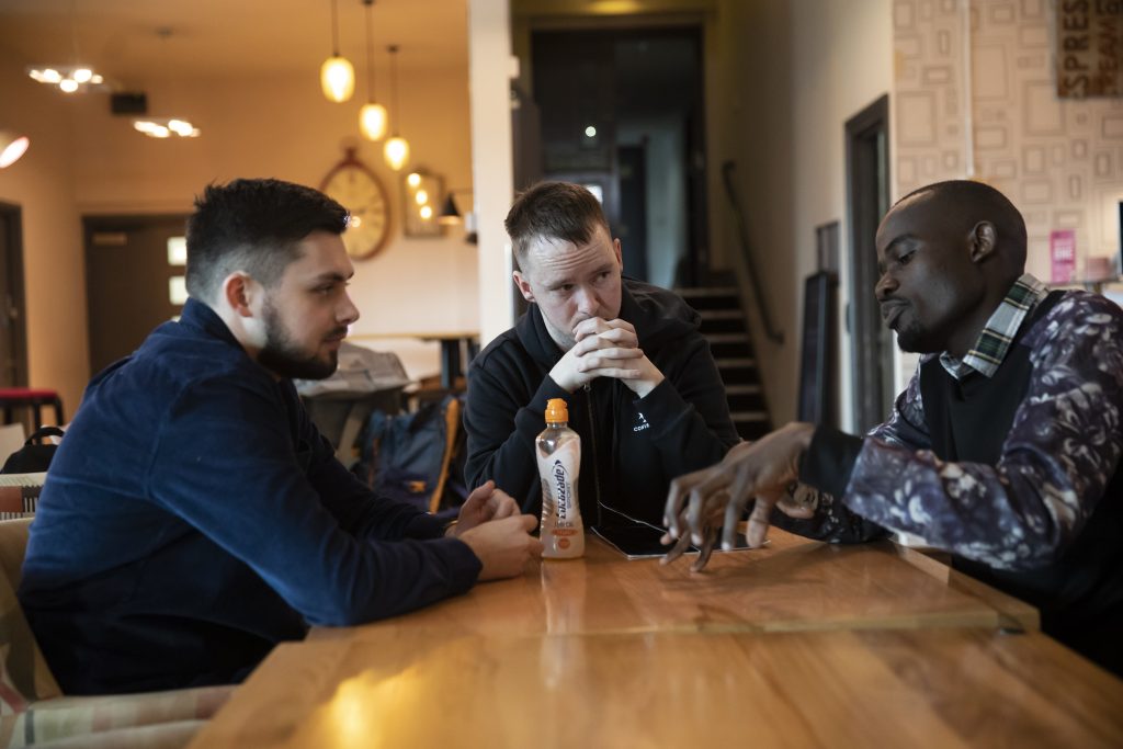 Three students sat around a table in Atmosphere