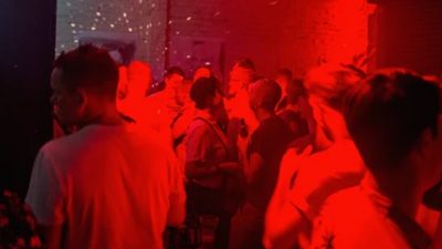 Photo of people inside a venue with red neon lighting