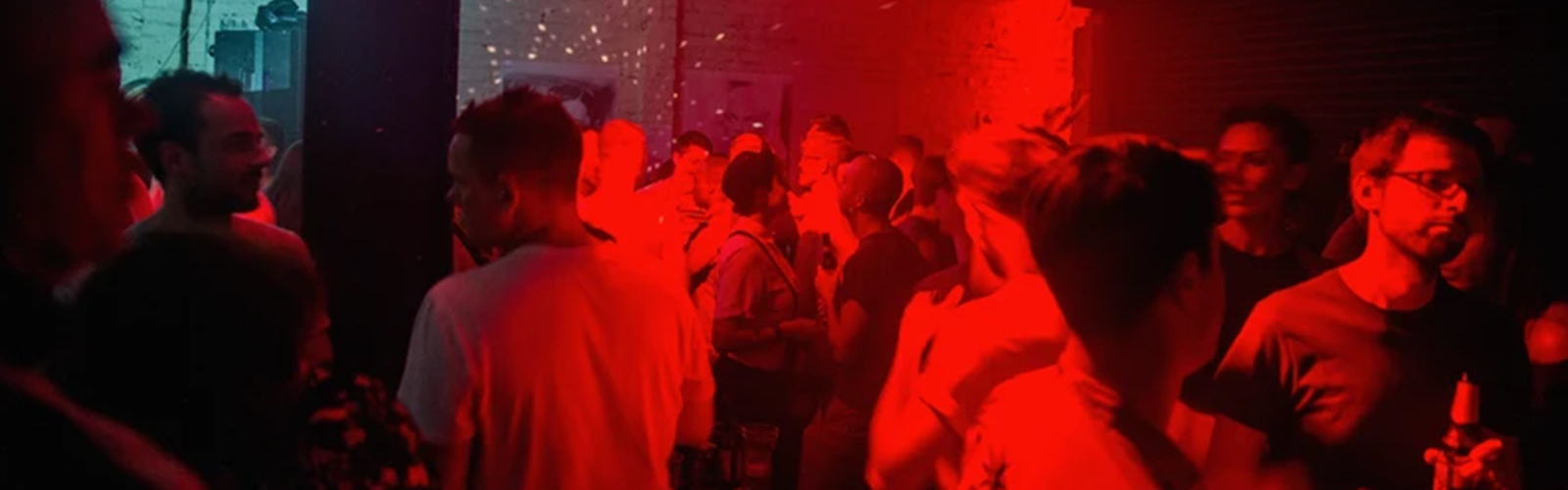 Photo of people inside a venue with red neon lighting