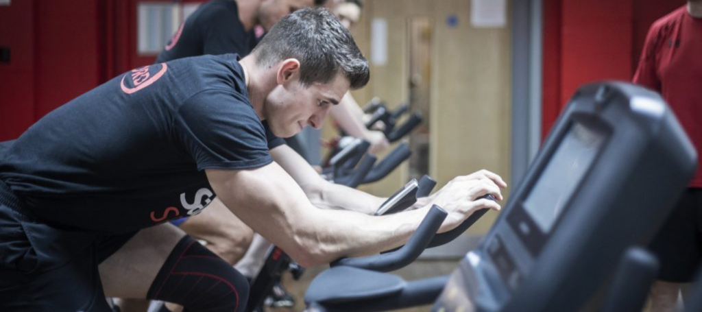Male student training on an exercise bike in the Sports Centre.
