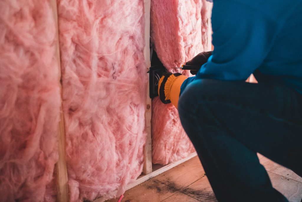 Person in blue pants doing insulation work