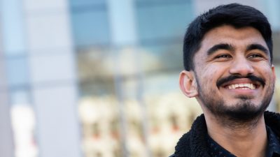 Photo of Sujan smiling outside the Chapman Building
