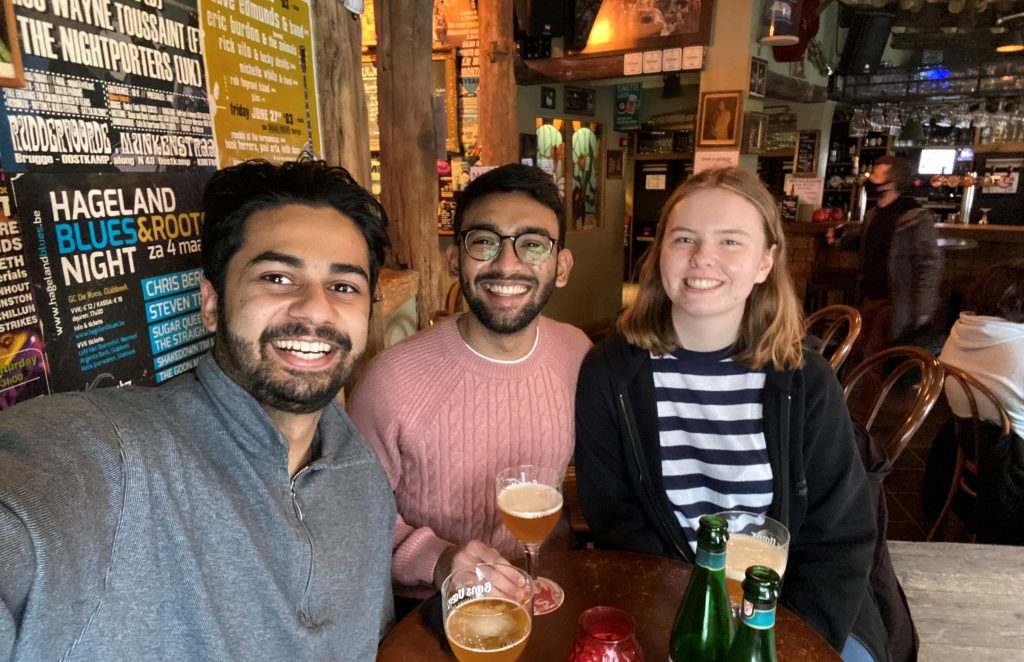 Prathmesh with two friends drinking beer in a pub in Leuven