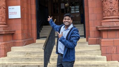 A picture of Durga smiling outside of Peel Hall