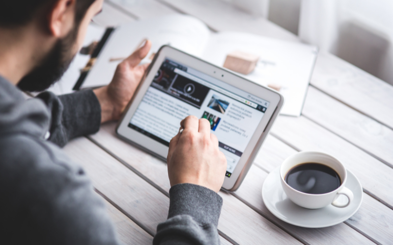 Man using a tablet to read a news article