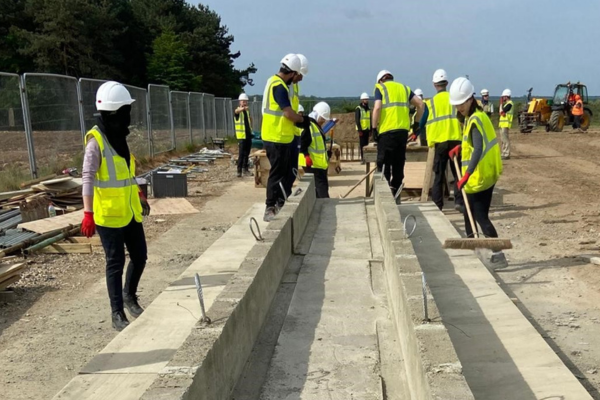 Students working in a group to build a bridge on a real life construction site