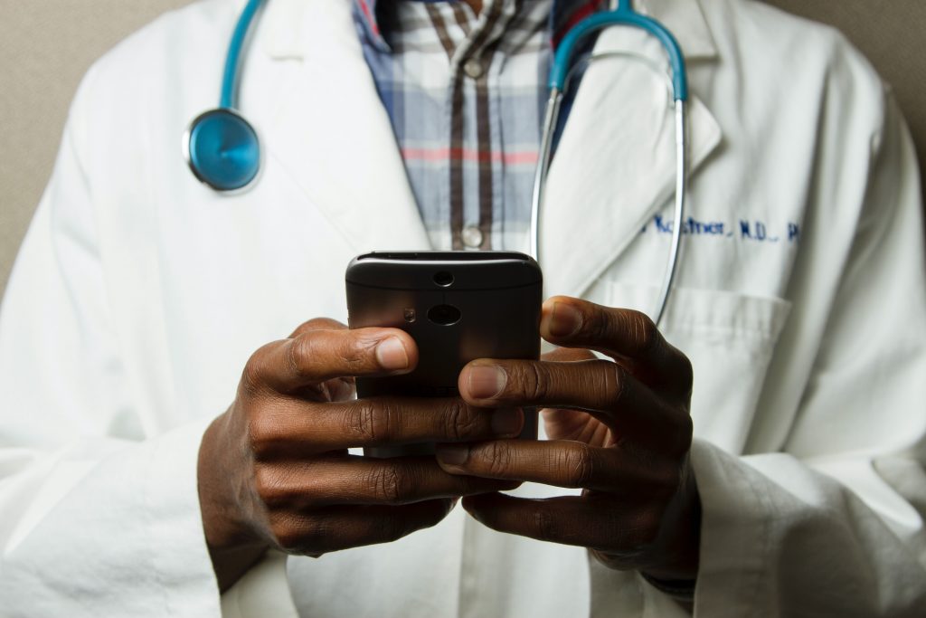 Photo of Doctor with suit on holding his phone
