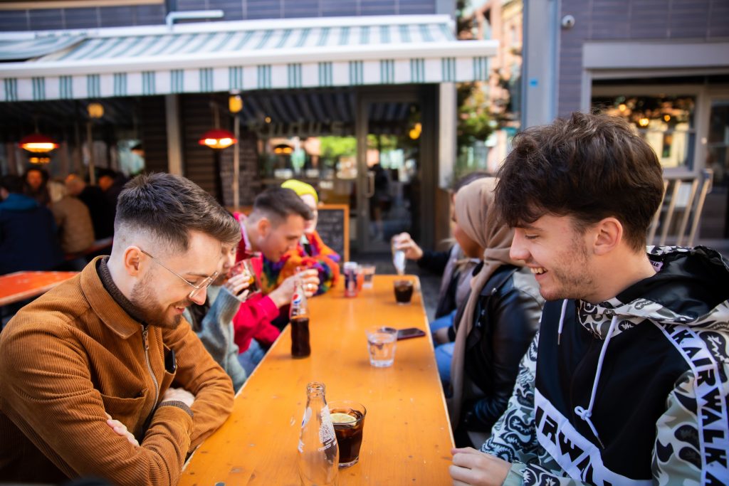 Image of students socialising with drinks on the table 