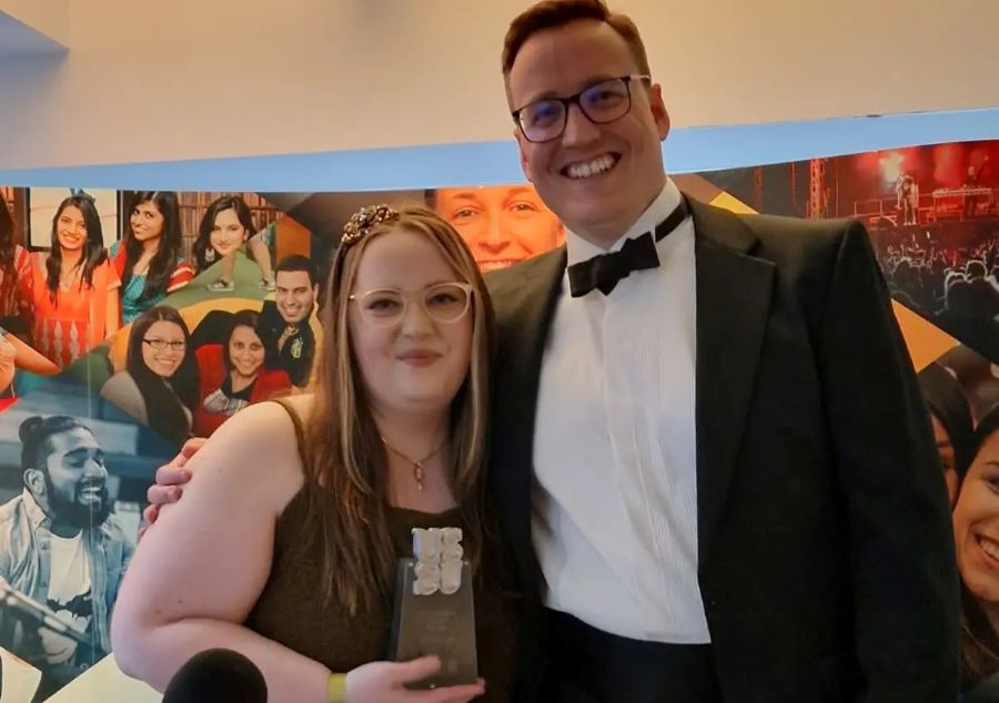 Emma and friend hold an award
