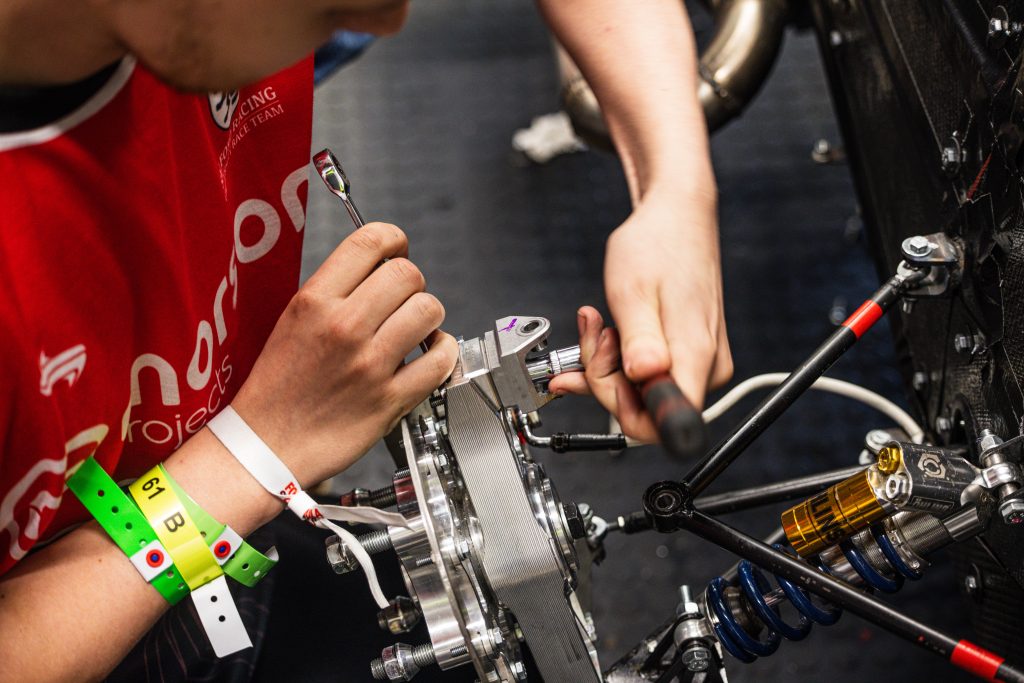 Image of a Salford Racing student working on car piece with equipment