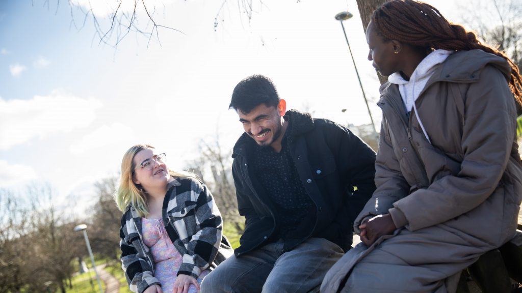 Three students sat outside talking