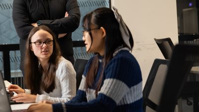 Two students writing their assignment.