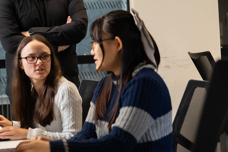 Two students writing their assignment.