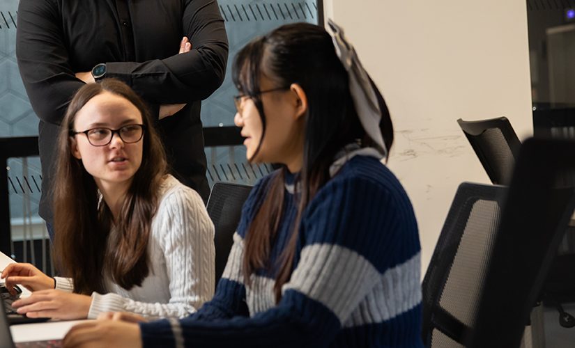 Two students writing their assignment.